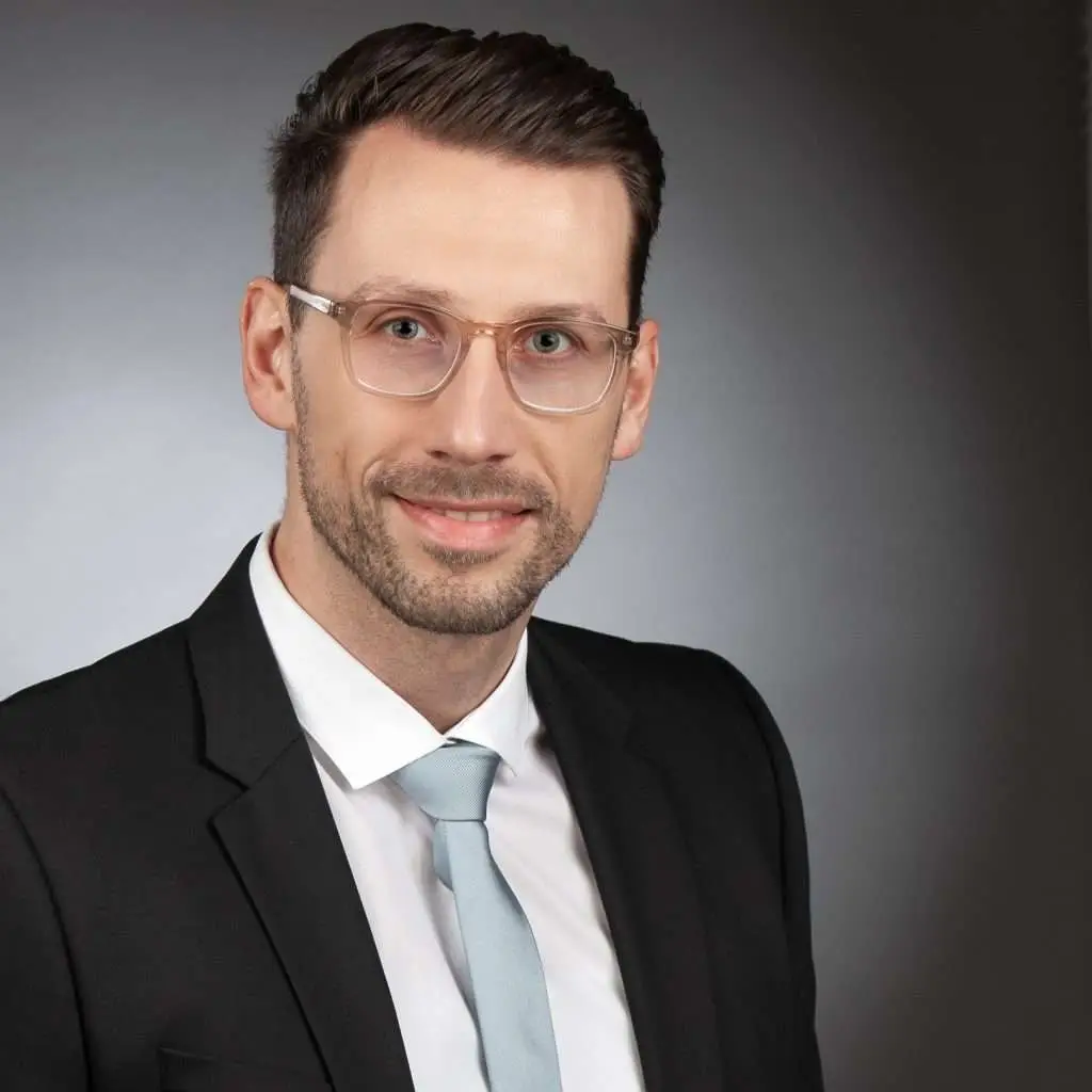 Mann mit Brille in Anzug und Krawatte